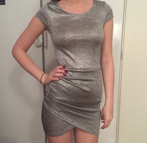  - Silvrig klänning, aldrig använd har prislappen kvar!