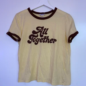 T-shirt - Ljusgul t-shirt i strl S, köpt från Monki men säljer för att den inte passar. Tryck i brunt med texten ”All together”. Lite slitet tryck, men knappt märkbart. Köparen står för frakt.