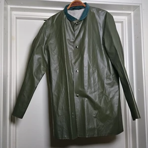 Regnjacka med manchesterkrage  - Sjukt fin lite längre regnjacka (vintage) med manchesterkrage. Grön färg. Står S i den men bedömmer den som större. Liten vit fläck som syns på andra bilden men den stör verkligen inte.🌸