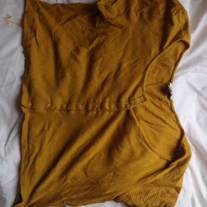 Gul Monki tröja  -  croppad topp med knappar, köpt på Monki. Den har en liten slitning längst ned men går säkert att sy eller klippa bort 
