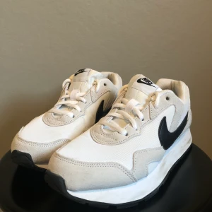 Nike skor - Coola Vita Nike skor med beigea detaljer och svart Swoosh. Storlek 38 dam. Använda fåtal gånger.