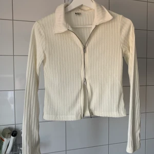 Vit tröja med dragkedja storlek XS - Trendig Oanvänd tröja då den var för liten för mig eftersom jag har storlek S, köpt från Nelly för några månader sen. Hör av dig om du är intresserad eller har frågor.