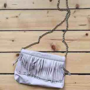  - Liten handväska/axelväska i "gammeldags"rosa skinnimitation med fransar och kedja.