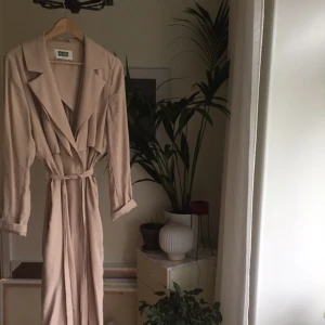  - Tunn trench från Weekday. Storlek L men jag har använt den som oversized. Går till mitten på vaden på mig som är 175 cm lång.