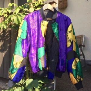  - This might be the coolest bomber jacket ever! Besides the heads in yellow, green and black on purple base, the extraordinary print also has Picasso's signature all over. But best of all is that you can turn it inside out and also get a black quilted bomber jacket!! 2in1, so smart!
The jacket is a kind of light, perfect for spring and early autumn but the slightly oversize style give room for a warm sweater which makes it versatile even in colder weathers. 
Apparently it was bought in a small boutique in London in the early nineties, but has never really been worn so it is as good as new. Grab the opportunity and get this on-of-a-kind-kind-of-jacket asap! 