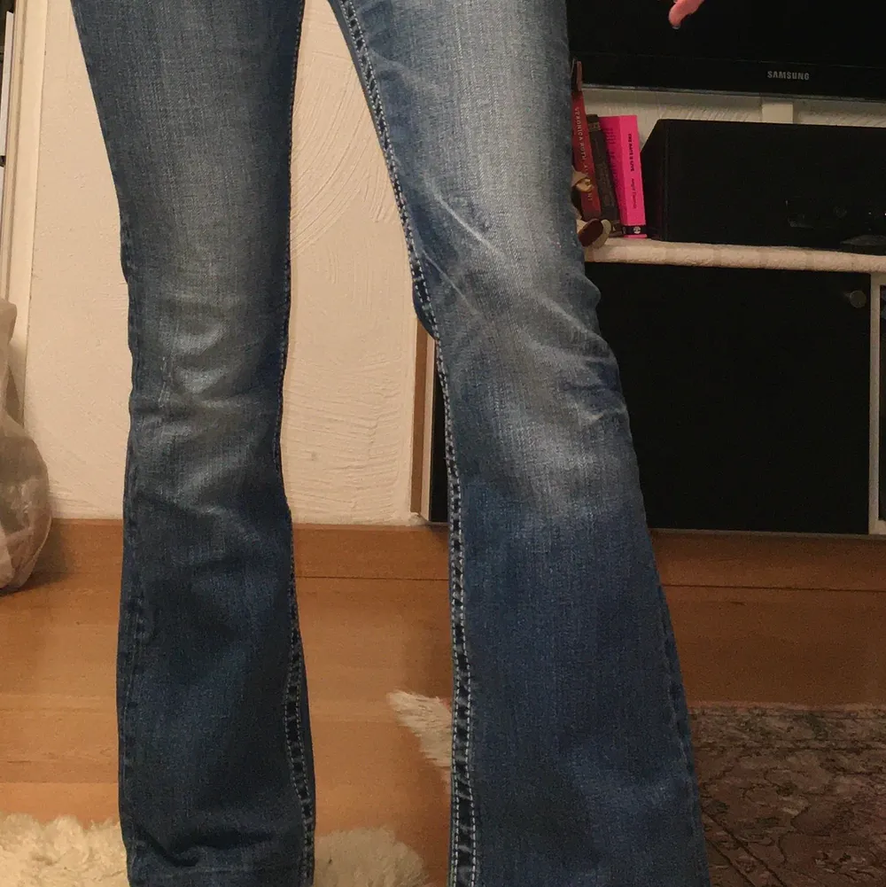 Lågmidjade Jeans med mycket bling från märket Miss Me jeans, typiskt trendiga byxor från tidigt 2000-tal. Byxorna är utsvängda nertill. Jag är 160cm och på mig går dom precis ner till fötterna.. Jeans & Byxor.