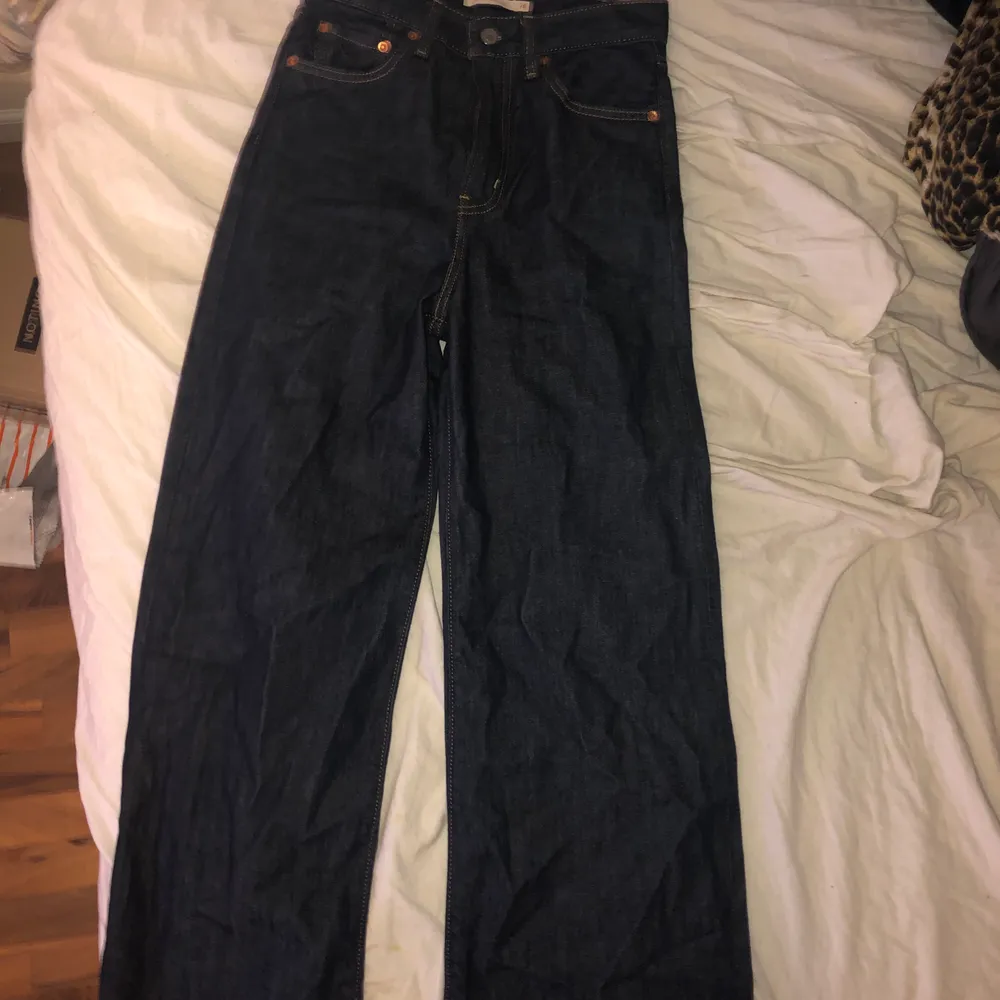 Säljer mina Levis wide leg jeans i supermörk blå färg. Väldigt högmidjade. Superfint skick och färgen passar sjukt bra nu på vintern! Storlek w.26, passar XS/S. . Jeans & Byxor.