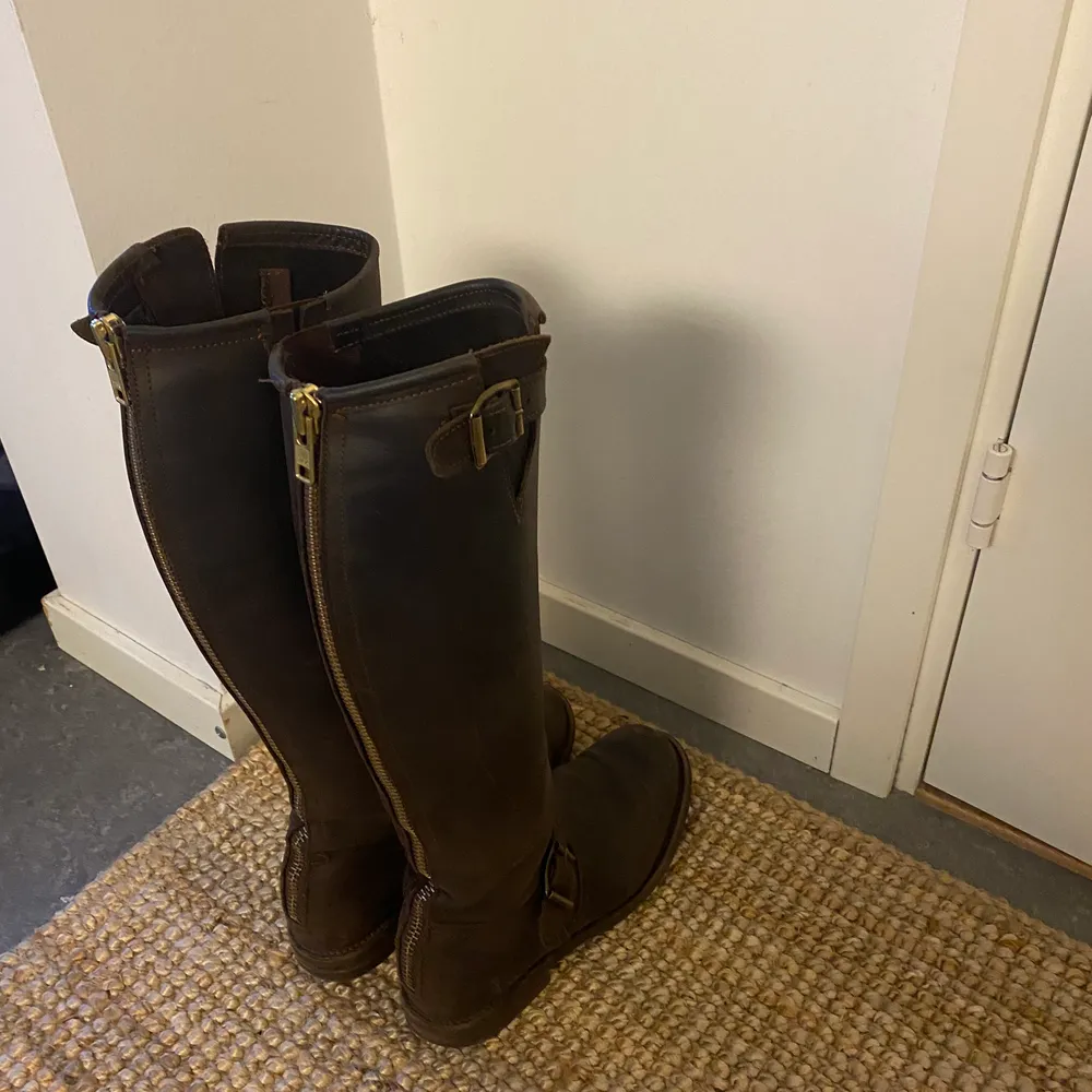 Höga primeboots i brun färg med guldiga detaljer. Några år gamla men sparsamt använda. Skor.