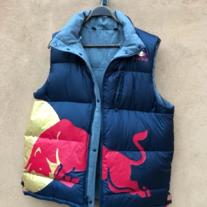  - Ruggigt snygg vändbar väst med Red Bull-tryck. Varm och skön. Avtagbar luva. Mycket fint skick. Ej storleksmärkt men sitter som en large. Hämtas i Uppsala eller skickas mot fraktkostnad