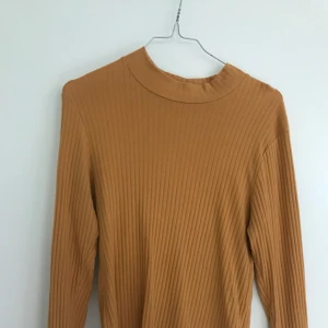  - Senapsgul/orange långarmad polo mer i storleken medium