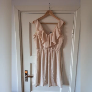  - Puderrosa klänning med volang i urringningen 