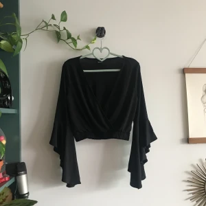  - Fin svart blus med trumpetärm, använd en gång.