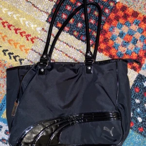 puma väska - säljer min snygga puma väska som jag fick av min mamma! jag har aldrig använt den (den är inte min stil) om jag skulle säga ett storlek skulle jag säga den är en M. du kan sätta en laptop o några skriv böcker. eller några kläder :)