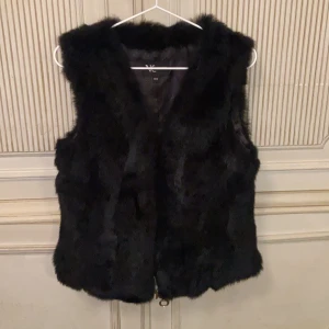 Pälsväst  - En svart pälsväst i mycket gott skick. Nypris 1499kr. Möts upp i Stockholm eller fraktar men då bekostar du det själv. 