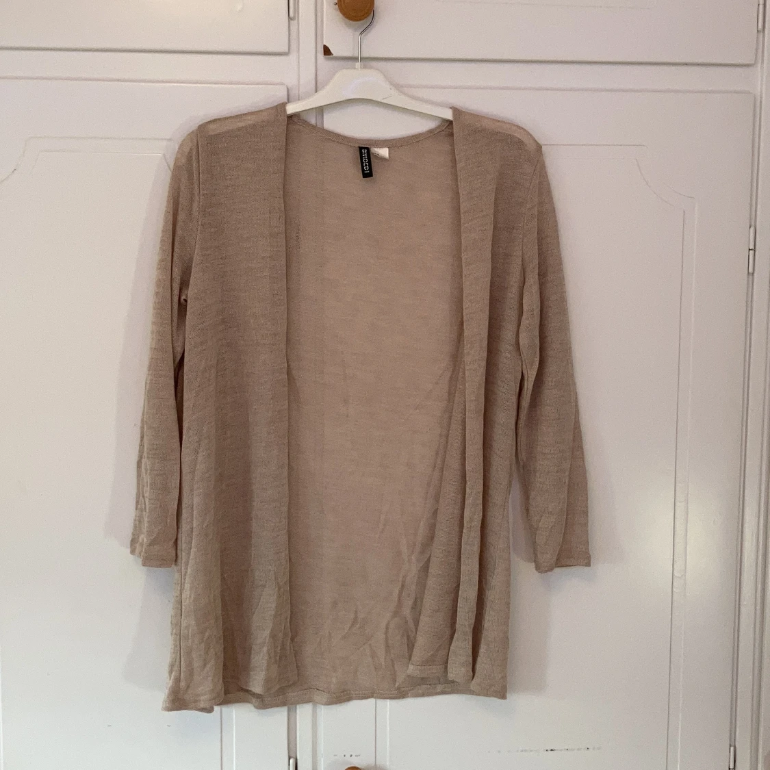 En tunn beige koftađđ