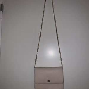 Rosa väska - En rosa liten väska med två olika band, en guldkedja och ett rosa i samma material som väskan