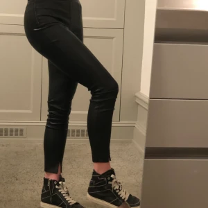 Faux Skinn Byxor - Mina sjukt snygga fake skinn byxor har tyvärr blivit lite för små för mig men är fortfarande i perfekt skick. Sömmen mitt på benet och slitsen är de perfekta detaljerna!! Jag är 170 cm och är vanligtvis en 38a!
