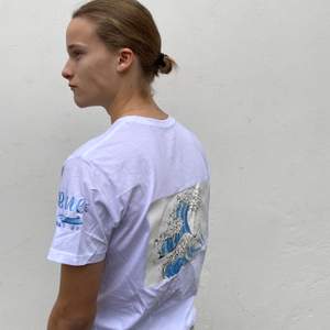 Storlek: S-L. En vit stilren t-shirt med ett tryck föreställande havet på tröjans baksida 🌊 20% av vinsten går till WWF 🌍💙