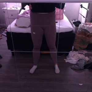 Träningstights  - Rosa träningstights med flera reflexer, dragsko i midjan och en dold ficka bak. Mycket fint skick.