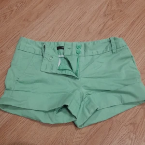 Shorts - Shorts lime gröna. Har både knapp och dragkedja. Strl 32 fina. Andvända 2 gg och är i väldigt bra skick