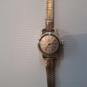 Damur OMEGA vintage  - Med fin armlänk ,uppvridningsbar fungerande mekaniskt urverk från Schweiz , gulmetall och rostfritt