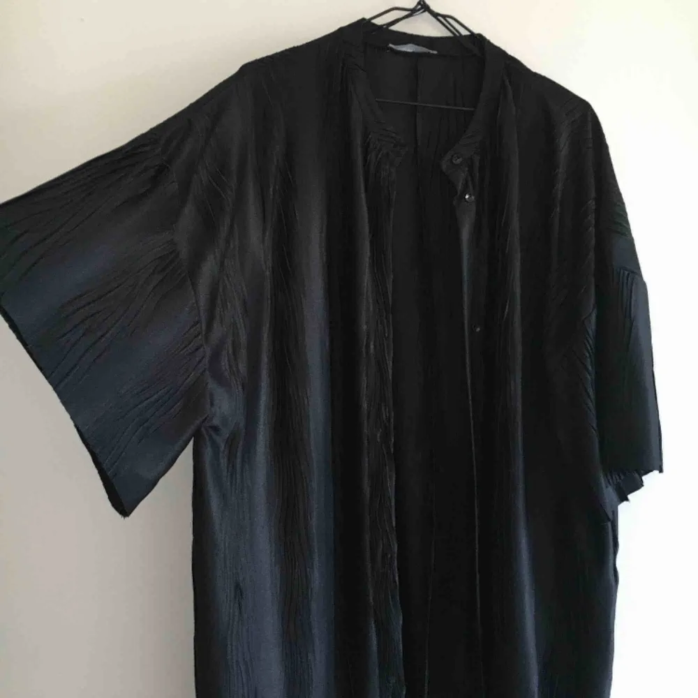 Kaftan/kimono köpt på Zara i ett svart lite transparent material. Kan knäppas fram. Märkt storlek S, men passar en XS-M. Når ner till strax under knät på mej som är 162cm. Oanvänd.. Övrigt.