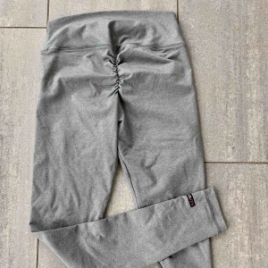  - Gråa träningstights från Alea Ware med detalj på rumpan, säljes pga fel storlek. väldigt sköna i materialet och använda max 5 gånger. frakt tillkommer