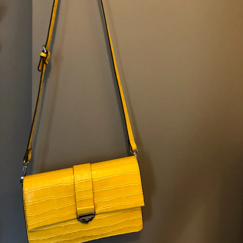 En gul väska från mango. Har använt några gånger men den är ett bra skick. Väskan går till revbenshöjd men längden går att ändra. . Väskor.