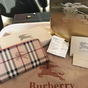  -  A ziparound wallet in Haymarket check and smooth leather. The spacious design features multiple internal compartments to keep coins and cards secure on the move.    Send me message if your interested😊😊