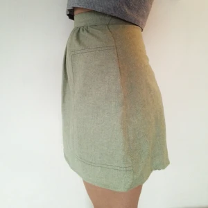  - Inklusive frakt! Jättefin kort kjol i tunt ulltyg! Dragkedja bak och två bra fickor på sidorna. Färgen är helt jämngrön i verkligheten, inte så flammig som på bilderna. Verkligen jättesnygg och bra kvalitet, men måste tyvärr sälja pga lite för liten.