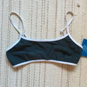  - Trendigt sportig bikinitopp i mörkgrå. Ny med tags kvar men köpt second hand och finns ett liiiiitet hål på (hör av er så skickar jag bild) men borde gå lätt att laga.
