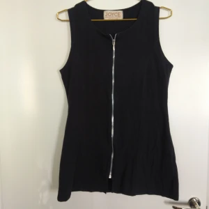  - Långt figursytt linne/kort klänning i svart/mörkgrått och dragkedja hela vägen ned på framsidan. Köpt i Frankrike. Gratis frakt!