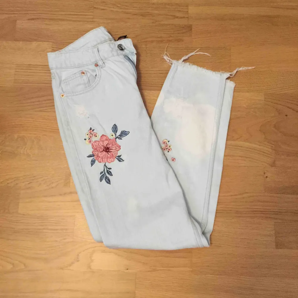 Ett par ljusblå mom jeans från hm, med ”broderad” blommor på. De har en fläck nere vid ena foten/vaden, därmed det låga priset! Pris går att diskutera vid snabbt köp!. Jeans & Byxor.