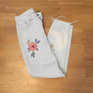  - Ett par ljusblå mom jeans från hm, med ”broderad” blommor på. De har en fläck nere vid ena foten/vaden, därmed det låga priset! Pris går att diskutera vid snabbt köp!