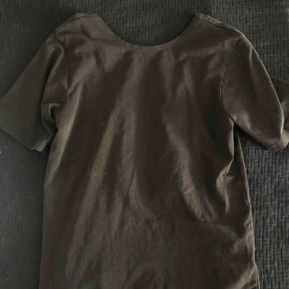 svart tshirt med coolöppning baktill med två stretchiga remmar. T-shirts.