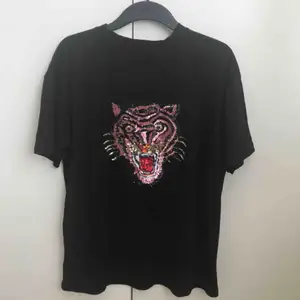 T-shirt med glittrigt tryck av en tiger. Oversize i storlek på någon som är XS/S