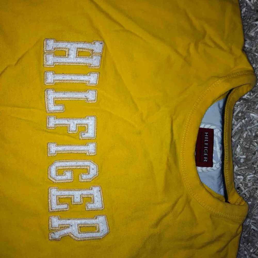 Cool gul Hilfiger tröja storlek M men passar S. Retro och jättebra skick!! . T-shirts.