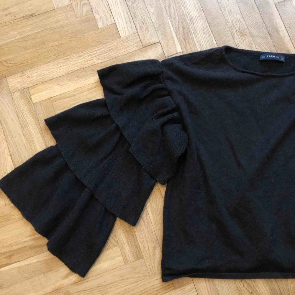 Stickad tröja med volangärmar i storlek S. Färgen är mörkgrå och tröjan är köpt på Zara. Använd ett fåtal gånger och är i mkt gott skick! #volang #zara . Stickat.
