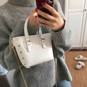  - Liten oanvänd väska från Åhléns. Har en scarf som man kan använda hur man vill. Har en skön tyngd på både väska och kedja.  Kan mötas upp i Stockholm eller Västerås, vid frakt betalar köparen