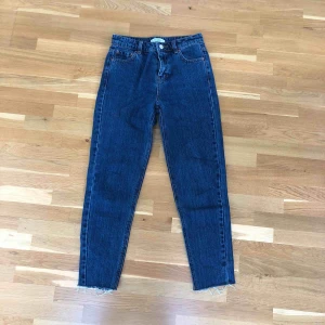  - Mörkblå jeans med en snygg stentvätt. Snygga slitningar vid ankeln. Mom jeans, alltså en lite lösare fit. Använd endast en gång. Frakt tillkommer.