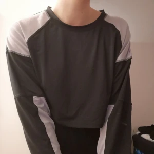  - Crooped tröja i svart och lila från Weekday. 87% polyester 13% elastan. Felfritt skick!