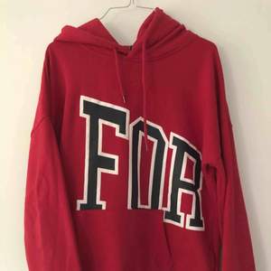 En röd hoodie med texten ”forever” på fram- och baksida. Något nopprig på magen men annars fin och mysig. 