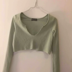  - Croppad top i ljus/pastell grön. Toppen är ribbad och slutar strax under brösten. Köparen betalar frakt :)
