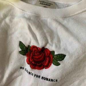  - Vit tjocktröja med en broderad ros och broderad text ”NO chance for romance” Fri frakt