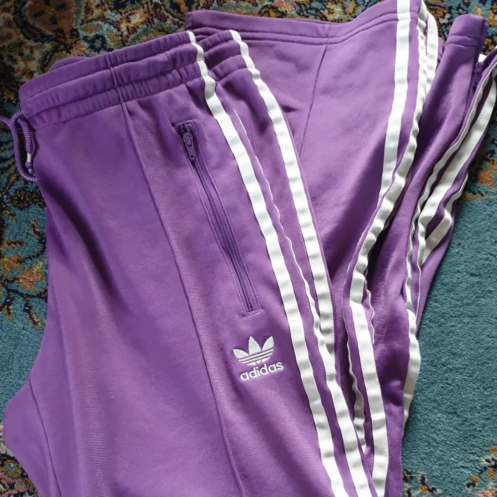 Adidasbyxor i fin lila färg. Ej storleksmärkta men jag skulle säga 36/38. Köparen står för frakt 🌹. Övrigt.