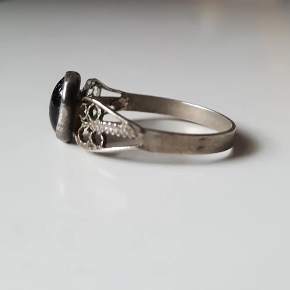 Vintage ring med svart sten i silver (stämplad 900).  Stenen är lite sned samt har några mindre repor. Fraktkostnad blir 11kr.. Övrigt.