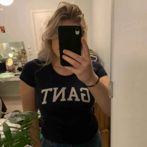  - En marinblå äkta ganttröja med ganttryck på bröstet i vitt. 