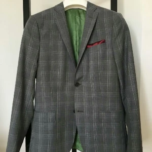  - Ljusgrå med inslag av ljusblå och vita mönster + Grönt innerfoder J. Lindeberg kavaj i perfekt skick.  · J. Lindeberg kavaj · Storlek: 46R, passform Slimfit · Köptes i J. Lindeberg butik (3600 kr) · Skick: Perfek