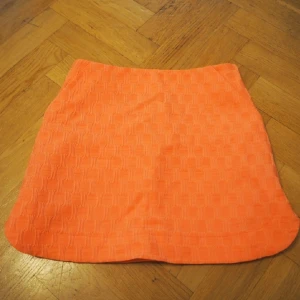  - rosa ej orange kjol med slitsar på sidorna samt fickor och dragkedja bak