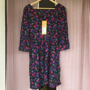  - Blommig knälång klänning från Beyond Retro i storlek M/36-38. Sitter tyvärr ingen storlekstagg i klänningen, men uppskattar att storleken är nått av dom! Klänningen är helt oanvänd med taggen kvar, nypris var 299kr. Säljes pga är aningen för liten för mig :(. 